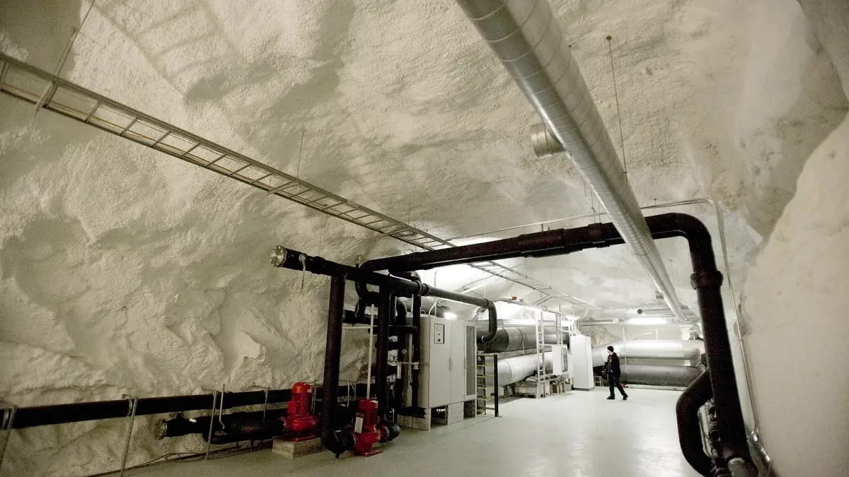 District cooling pipes and pumps along the rock wall of a tunnel at a data centre in Helsinki, Finland