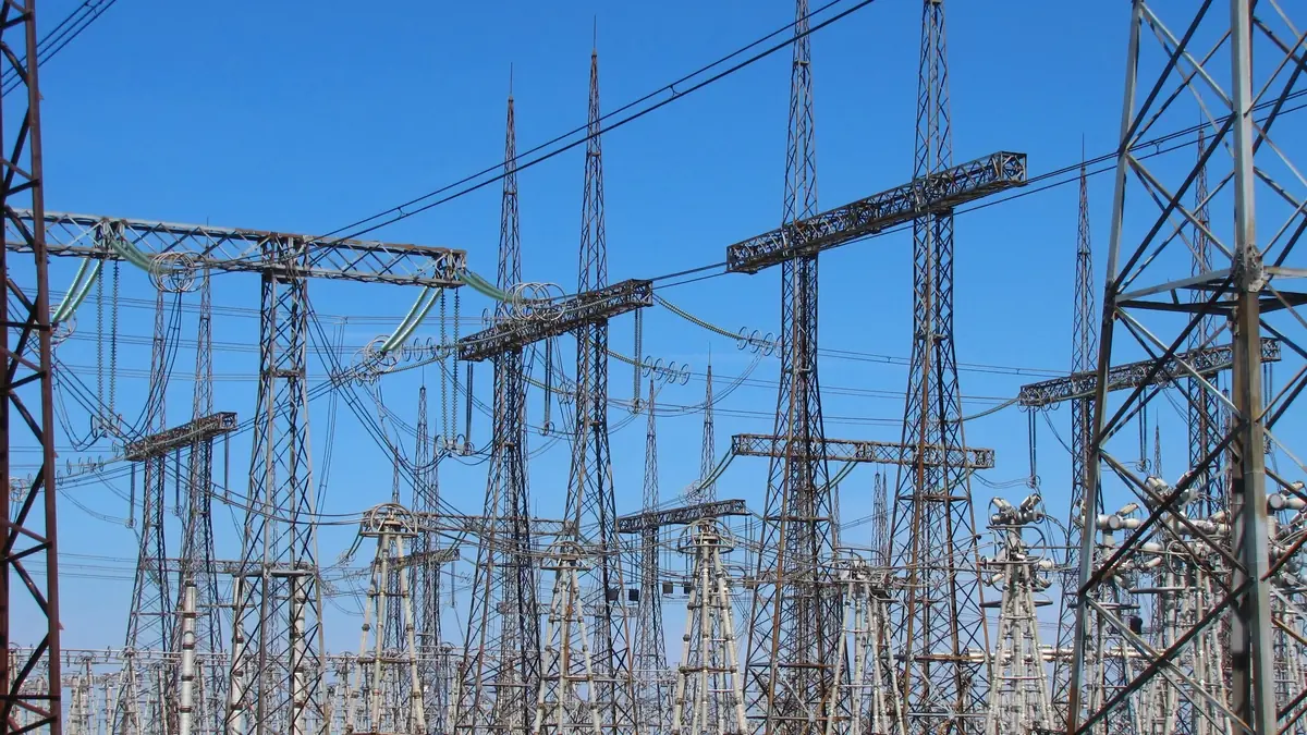 Lattice steel gantries, insulators and conductors in the switchyard of a 750 kV electrical substation