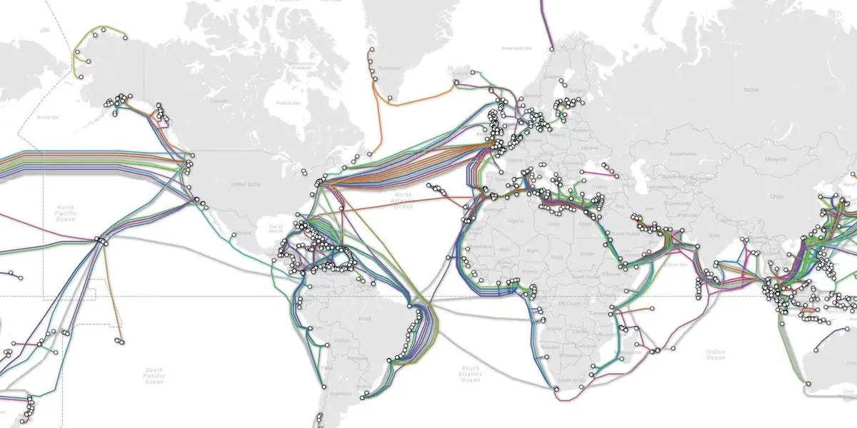 World map of submarine communications cables, with coloured cable routes and white landing-point markers
